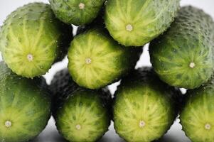 Visually appealing arrangement of fresh, green cucumbers, stacked to form a vibrant close-up image. photo