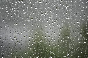 Raindrops on a window create a beautiful, abstract scene with a blurred background. photo