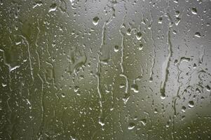 Raindrops on a window create a beautiful, natural pattern with blurred, abstract textures. photo