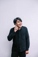 Cheerful young man has an idea and shows a finger up gesture photo
