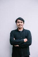 Confident smiling asian man portrait with arms crossed on neutral background photo