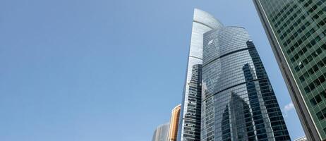 Modern Skyscrapers Reflect Sunlight Against a Clear Blue Sky in Moscows Bustling Cityscape photo