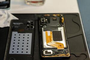 Expert Phone Repair Process With Open Smartphone, Tools, and Components at a Local Repair Shop During the Day photo
