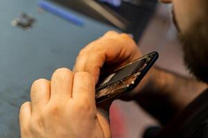 Expert Technician Repairing a Smartphone in a Busy Phone Repair Shop During Afternoon Hours photo