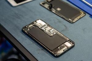 Expert Phone Repair Under Way on a Workbench With Disassembled Smartphone Components and Tools Present photo