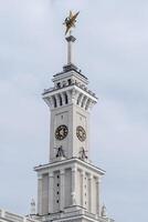 Historical Clock Tower With Golden Star and Intricate Architectural Details Under a Cloudy Sky photo