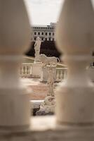 Stunning View of Classical Sculptures in a Historic Garden Framed by Ornate Pillars During Daylight photo