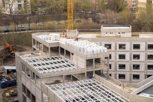 Construction Site Showcasing Progress on a Multi-Story Building With Cranes and Materials Present in an Urban Landscape During Daytime photo
