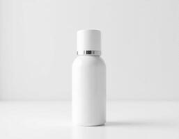 White cosmetic bottle with a silver cap on a white surface photo