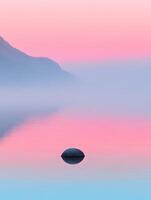 A serene landscape featuring a smooth rock in calm water under a pastel colored sky at dawn or dusk photo