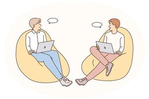 Smiling male colleagues talk working on laptop vector