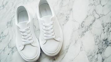 White Sneakers Resting Elegantly on a Polished Marble Surface photo