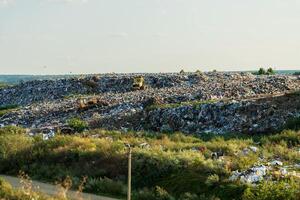 Environment pollution. Garbage pile in trash dump or landfill. Two bulldozers are working at a landfill. photo