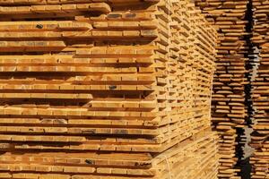 A stack of boards. The boards are stacked on the sawmill. Sawing boards on a sawmill. Production of wood material photo