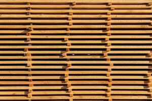 Vertical wooden slats are meticulously arranged to form a textured wall, showcasing natural wood grain in a brightly lit environment, creating a warm atmosphere photo