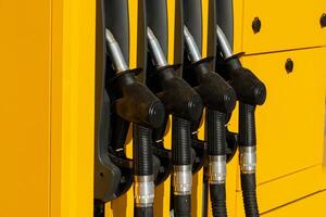 Multiple fuel dispensers stand ready at a vibrant yellow gas station, reflecting bright sunlight on a clear day. The scene highlights an accessible refueling experience photo