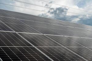 A rooftop is covered with solar panels, efficiently collecting sunlight for energy as clouds pass overhead, highlighting a commitment to renewable resources photo