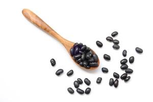 black beans on spoon on a white background photo