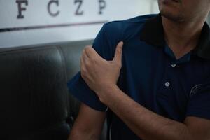 a man in a blue shirt is holding his arm photo