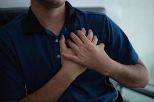 a man is holding his chest in pain photo