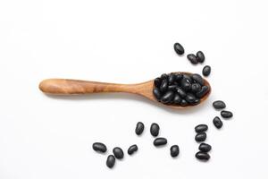 black bean on wooden spoon on a white background photo