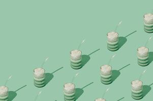 Creative summer pattern made of iced matcha latte on pastel green background. Minimal healthy matcha latte concept. Trendy drink idea. Copy space. photo