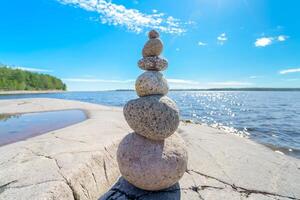 Pyramid of stones. Six stones on top of each other. Unstable balance of stone objects. Idyllic state of nature. photo