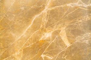 Texture of stone marble. Golden surface of marble stone with striped streaks. photo