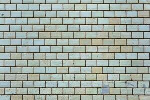 Wall of vintage bricks covered with cracked glaze. Bricks are arranged in a pattern. photo