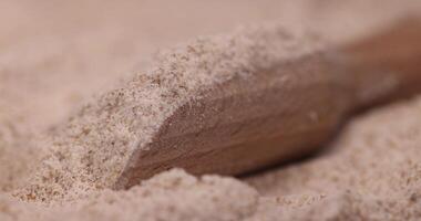 A wooden spoon is sitting on top of a pile of sand photo