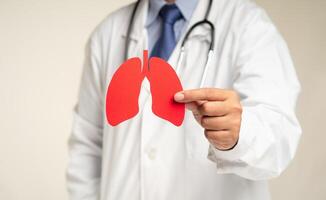 Close-up of a doctor holding a lung shape symbol while standing in the hospital. photo