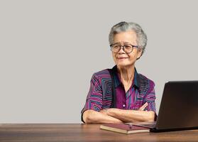 Portrait of an elderly Asian woman looking at the camera with a smile while sitting at the table photo