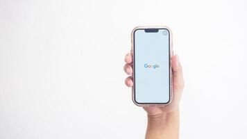Yogyakarta, Indonesia, 2025 - Hand holdingHand holding smartphone that shows opening page of Google application, a search engine platform, on screen isolated on white background photo