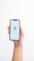 Yogyakarta, Indonesia, 2025 - Hand holdingHand holding smartphone that shows front page of Gojek application, on-demand service platform, on screen isolated on white background photo
