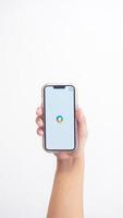 Yogyakarta, Indonesia, 2025 - Hand holdingHand holding smartphone that shows Google application icon, a search engine platform, on screen isolated on white background photo