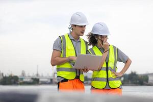 Industrial Workers with Laptop Overseeing Operations at a Commercial Dock, Port Engineers Team Discussing Logistics at a Shipping Yard, Team of Maritime Professionals Planning at a Harbor photo