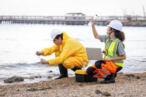 Environmental Scientists Collecting Water Samples for Analysis, Researchers Testing Water Quality at a Lake or Coastal Area, Water Pollution Control photo