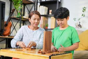 Mother and Son Playing Block Game in Living Room at Home, Happy Asian Family Bonding with Fun Indoor Game photo