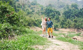 Couple Hiking and Enjoying Scenery in Nature, Happy Travelers Exploring Lush Green Mountains photo