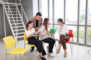 Diverse Business Team Brainstorming and Discussing Ideas, Young Asian Professionals Collaborating in Modern Office, Casual Business Meeting, Colleagues Sharing Insights photo