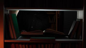A person in a black jacket standing in front of a bookcase video
