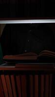 A person sitting in a chair with a book on a shelf video