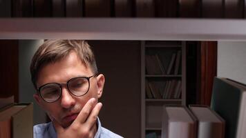 University student wearing glasses, contemplating which book to select while surrounded by towering bookshelves in a bustling college library, immersed in the pursuit of knowledge video