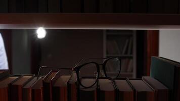 A pair of glasses and books on a shelf video