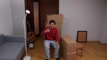 Man drinking water and eating banana while taking a break from moving into new apartment video