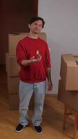 vertical close-up contented happy man in new apartment throwing keys in hand video