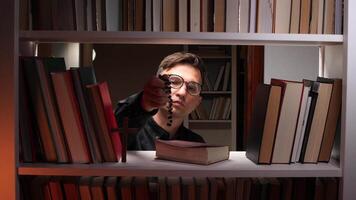 Male librarian displaying rosary beads and a wooden cross among a vast collection of books on a library bookshelf, blending themes of religion, knowledge, and spirituality video