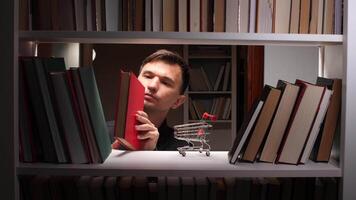 Man looking through a book shelf with a shopping cart video