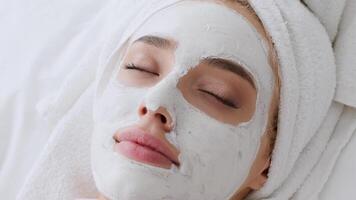 In a bright home setting, a young blonde woman applies a rejuvenating mask while relaxing in the morning. The peaceful atmosphere highlights her dedication to self-care and wellness. video