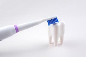 The Modern electric ultrasonic toothbrush with rechargeable battery with a tooth. photo